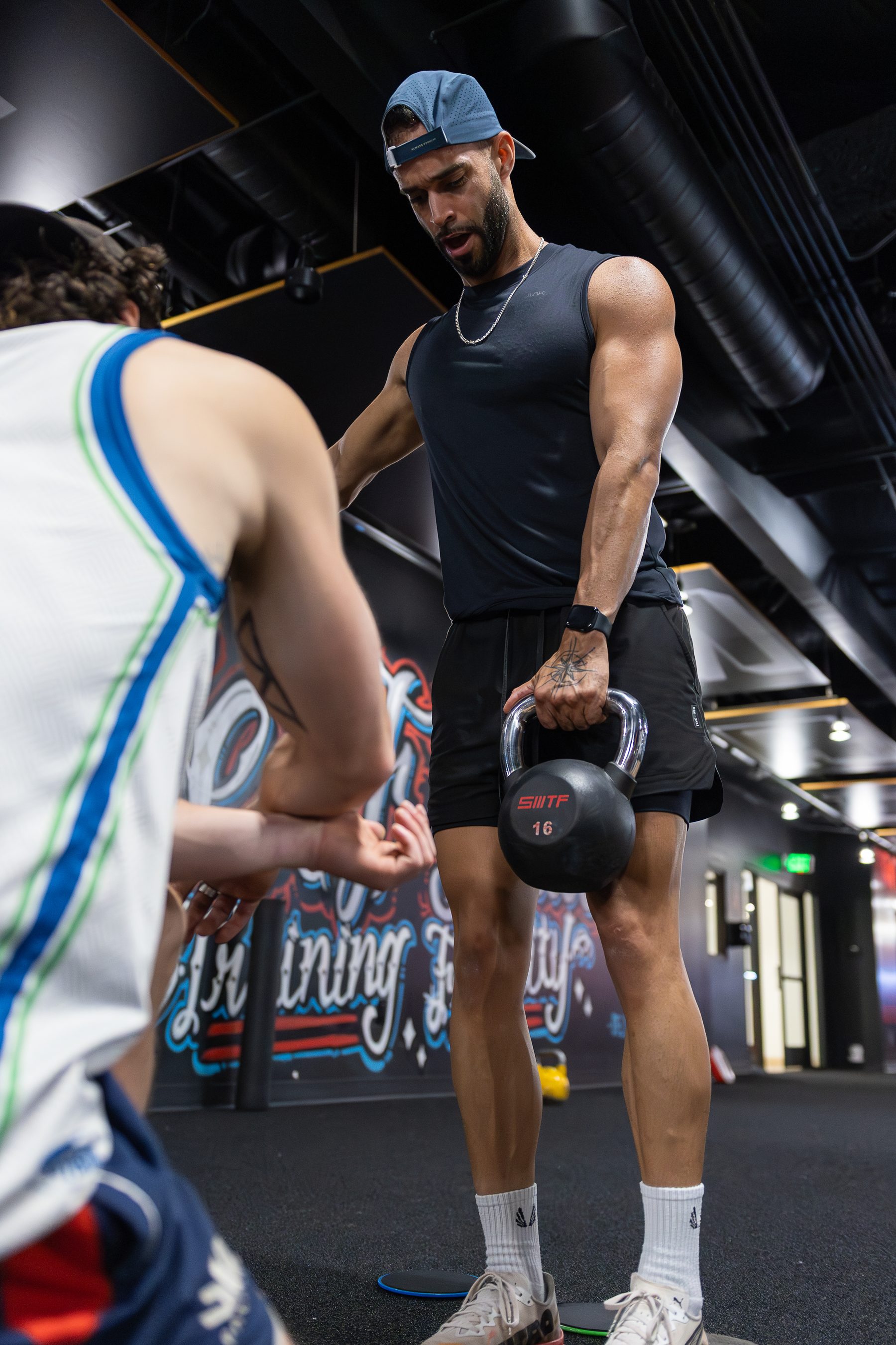 Coach and member working with a kettlebell at Legacy Del Mar