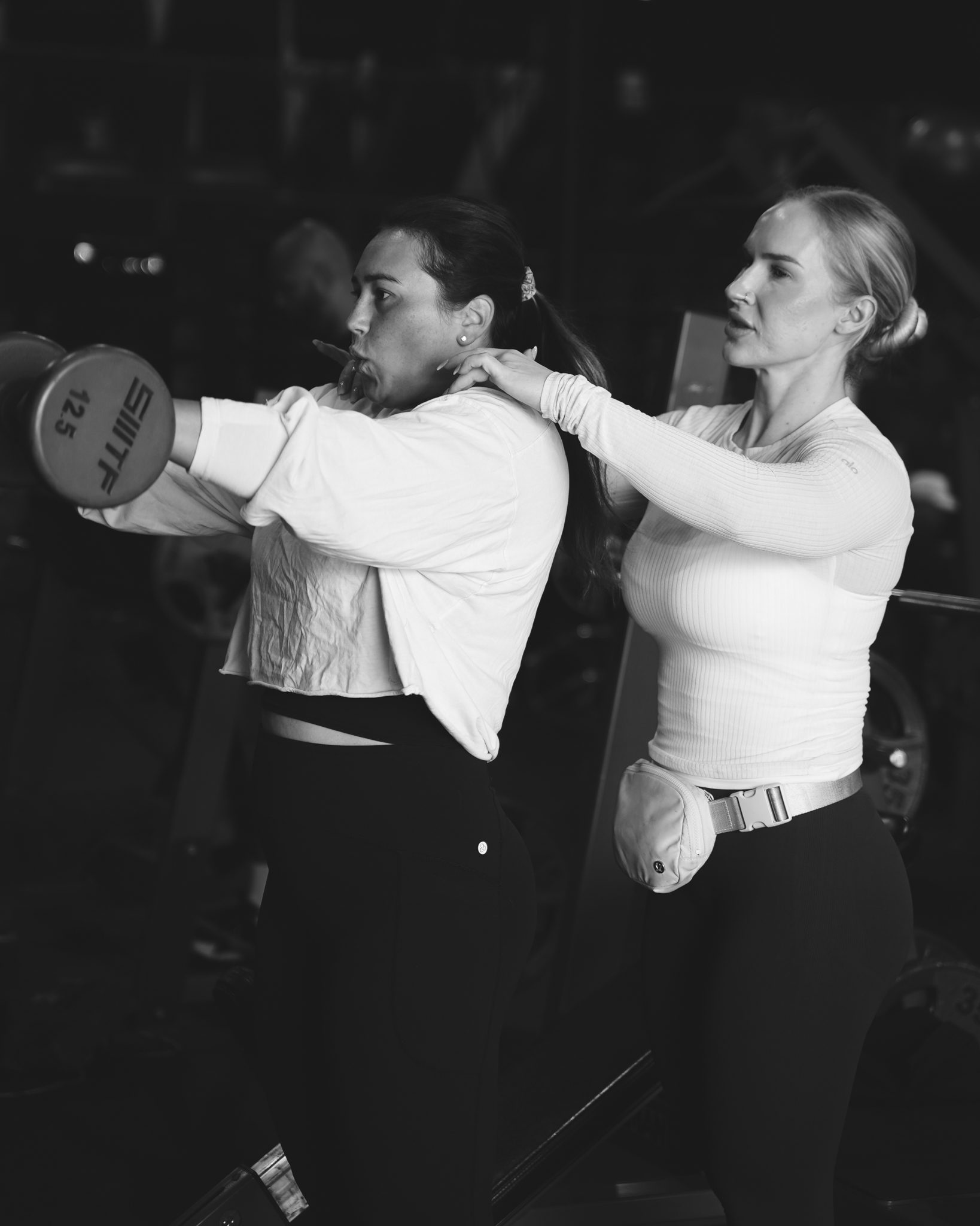 Coach cueing a client through a dumbbell press at Legacy San Diego